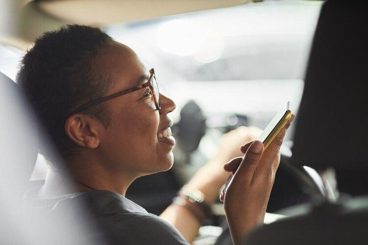 close-up-african-young-woman-talking-mobile-phone-smiling-while-driving-by-car_236854-27345